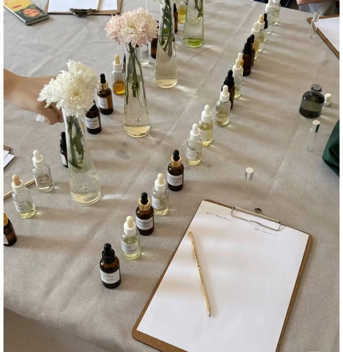 Essenceflesjes en bloemen op de tafel van een parfum workshop voor een vrijgezellenfeest